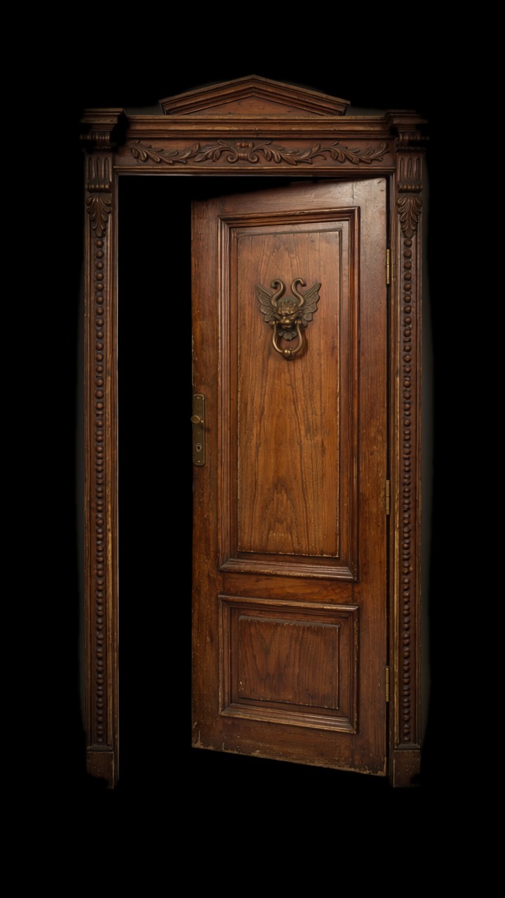 Puerta antigua semi abierta con aldaba de bronce